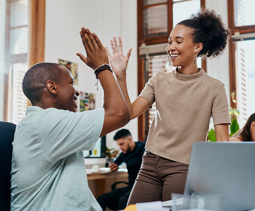 excited young employees colleagues with computer at workplace